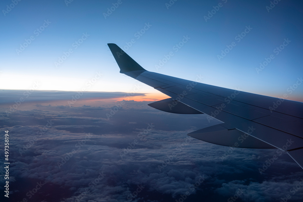 Naklejka premium airplane wing against sunset sky