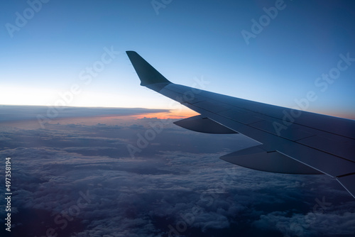 airplane wing against sunset sky