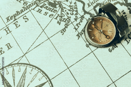 Magnetic old compass on world vintage  map.Travel, geography, navigation, tourism and exploration concept background.Macro shot, shallow focus.