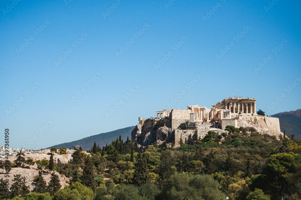 View of the ancient Athenian Acropolis on a hill with trees, Athens, Greece.