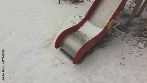 children's slide in the playground lonely falling snow in the spring. High quality 4k footage