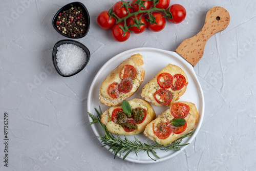 Italian bruschetta with roasted tomatoes, mozzarella cheese and herbs 