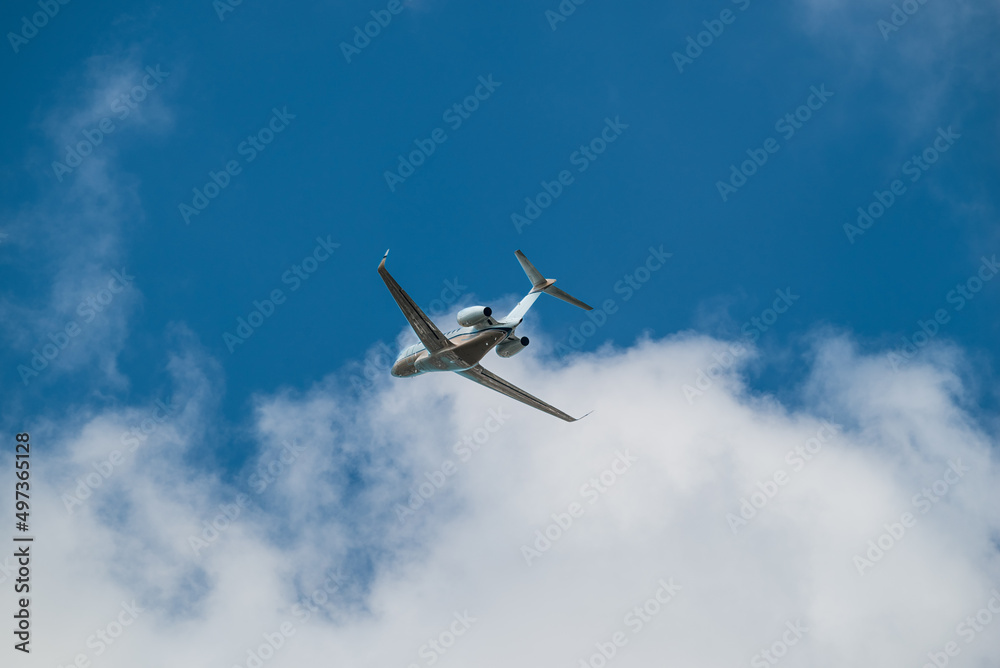 Airplane Jet flying overhead against blue sky and white clouds Airplane Jet flying overhead against blue sky and white clouds