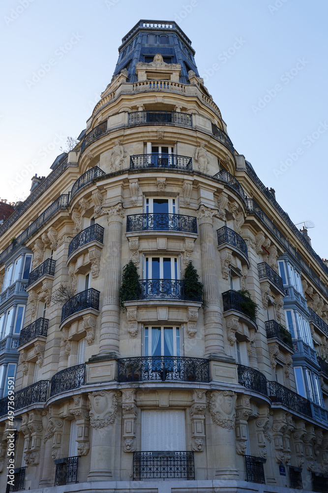 The facade of traditional French house with typical balconies and windows. Paris.