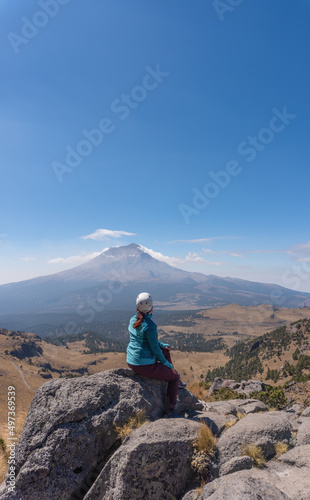 Female hiker looking at steaming volcano