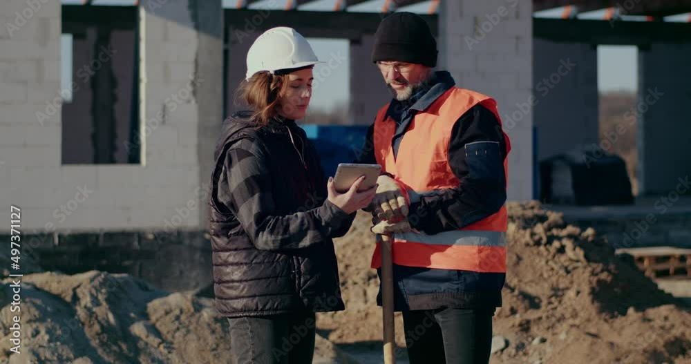 Concentrated Engineers discussing, examining and developing at Construction Site Concentrated Engineers discussing, examining and developing at Construction Site
