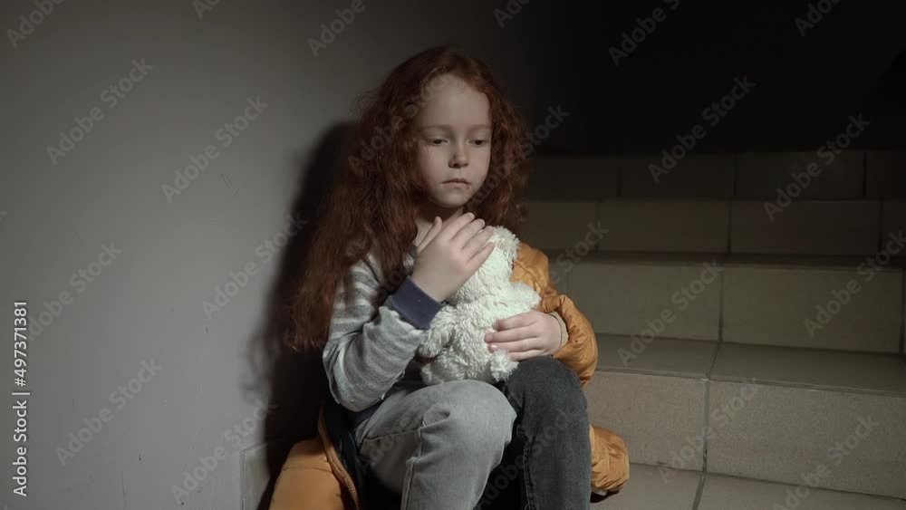 A little Ukrainian, sad, curly-haired girl sits in the dark on the stairs with a teddy bear. She is from Odessa
A little Ukrainian, sad, curly-haired girl sits in the dark on the stairs with a teddy bear. She is from Odessa