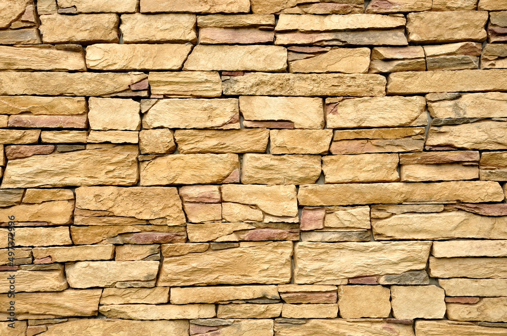 Part of the beige stone wall. Brown rock wall background texture. Part of the beige stone wall. Brown rock wall background texture.