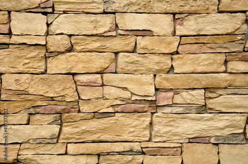 Part of the beige stone wall. Brown rock wall background texture.