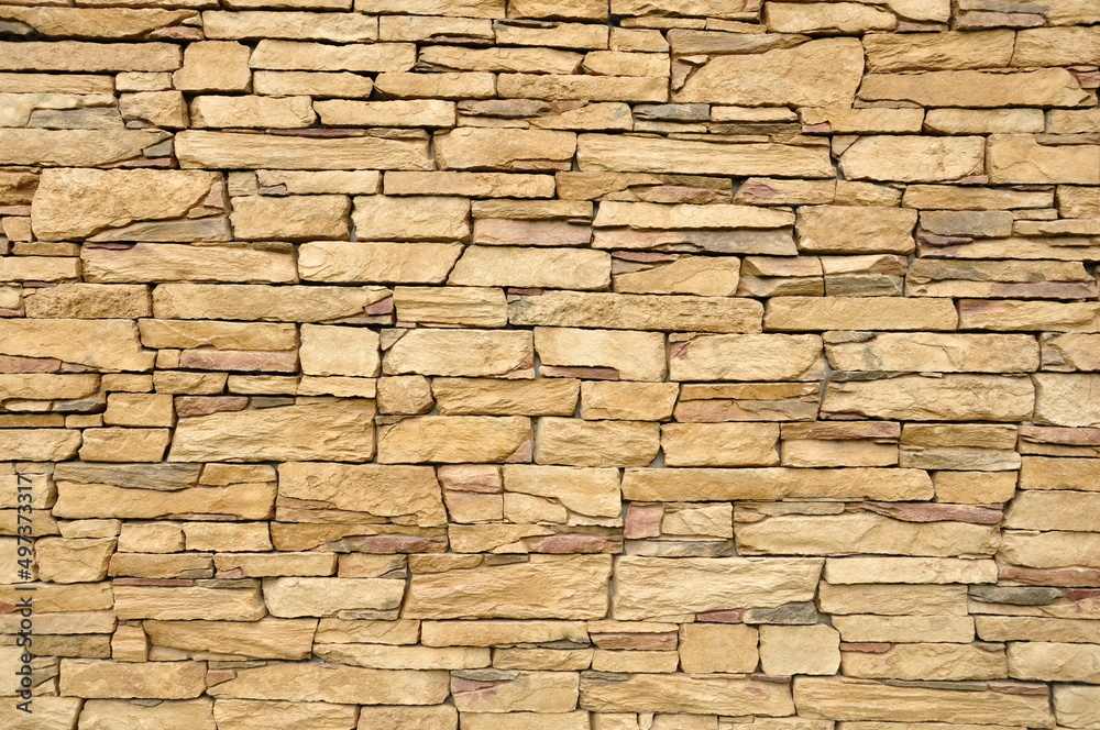 Part of the beige stone wall. Brown rock wall background texture.