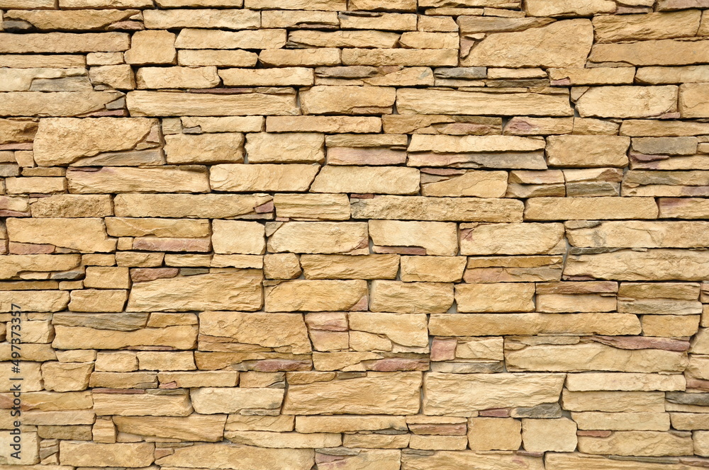 Part of the beige stone wall. Brown rock wall background texture. Part of the beige stone wall. Brown rock wall background texture.