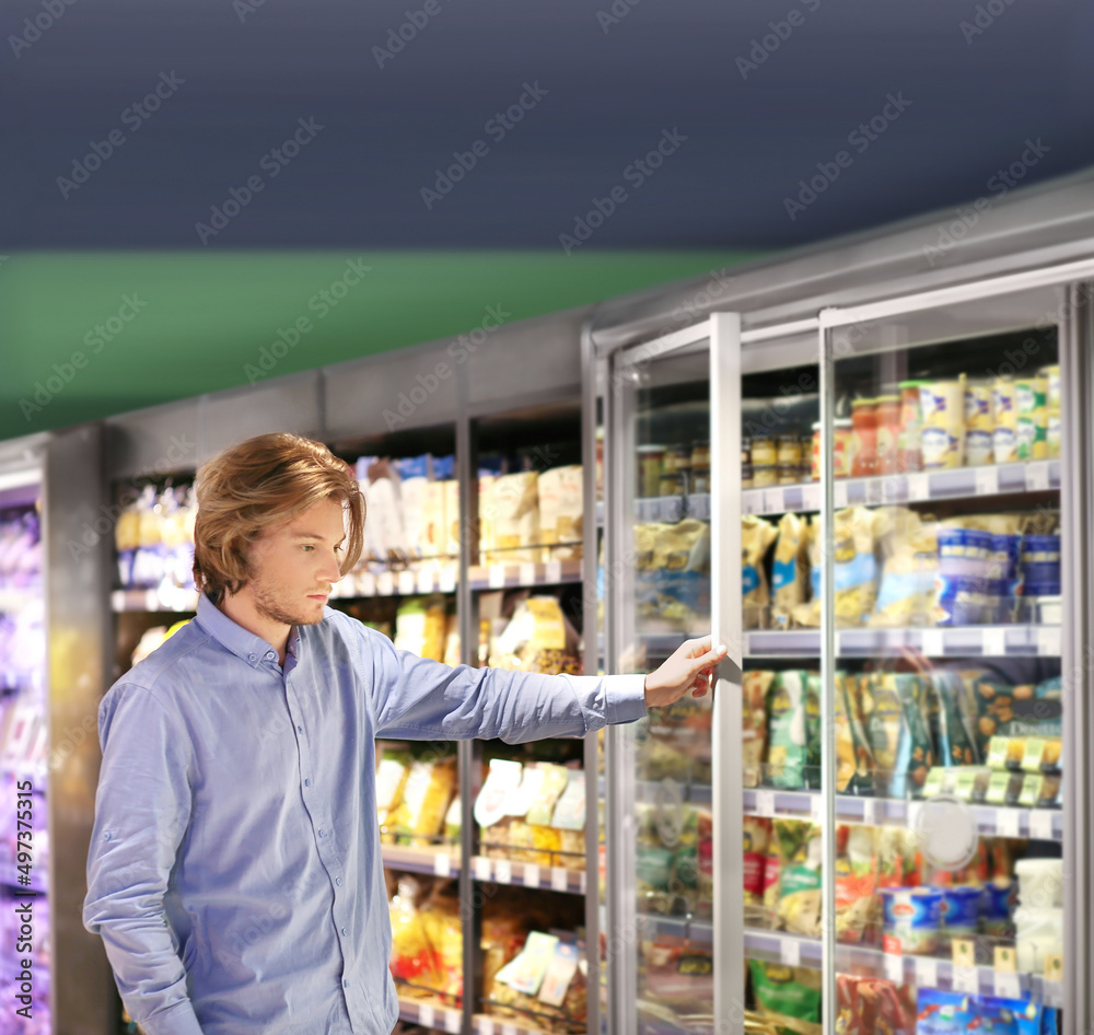 Man choosing frozen food from a supermarket freezer.