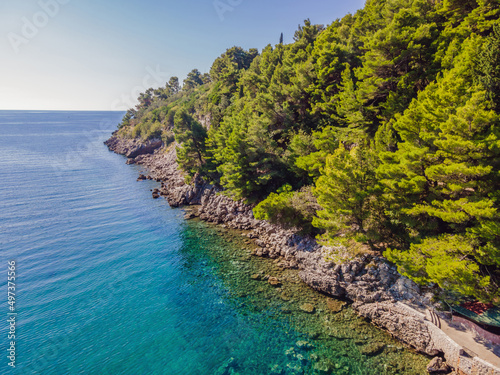 Picturesque sea Adriatic coast of Montenegro. Turquoise Mediteran sea and rocky shore with evergreen coniferous trees. Wonderful summer landscape. Drone