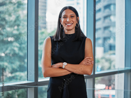 Free Download Work hard to become the best version of yourself. Portrait shot of a young businesswoman standing with her arms crossed at work. - GFXLoad