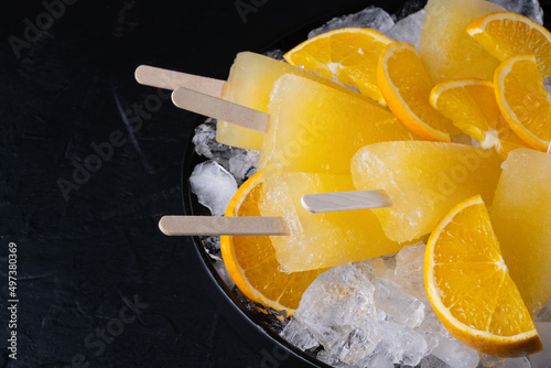 Fruit orange ice lolly and slices of orange. Top view. Copy space photo