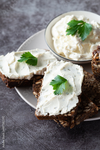Rye bread with cream cheese on grey table. Whole grain rye bread with seeds