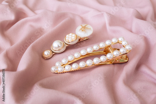 pattern of hair clips with pearls on pink fabric background