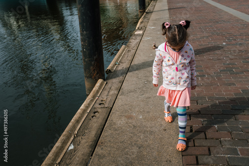 young girl walking outside near water