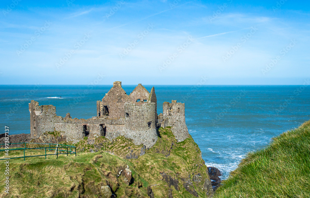 Famous Dunluce Castle in Northern Ireland with blue sea background in a sunny day.