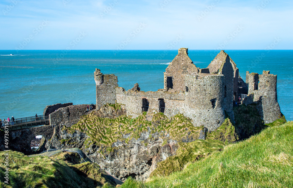 Famous Dunluce Castle in Northern Ireland with blue sea background in a sunny day.
