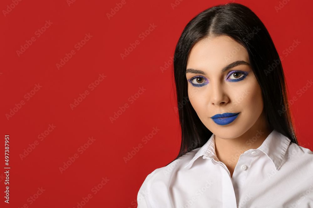 Beautiful young woman with creative makeup on red background Beautiful young woman with creative makeup on red background