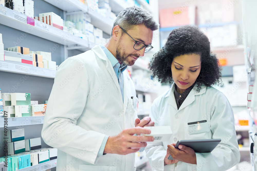 Nothing says well run pharmacy like teamwork. Shot of a mature man and young woman using a digital tablet together while working in a pharmacy.