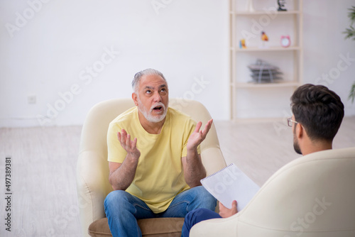 Old man visiting young male psychotherapist
