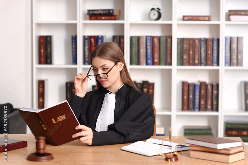 Female judge with book at workplace in courtroom Female judge with book at workplace in courtroom