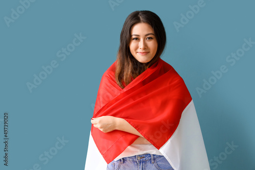 Young Asian woman with flag of Indonesia on blue background