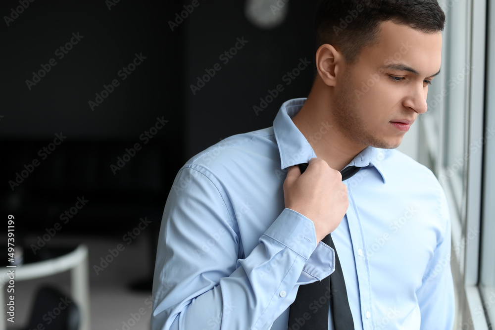 Worried young businessman near window in office Worried young businessman near window in office