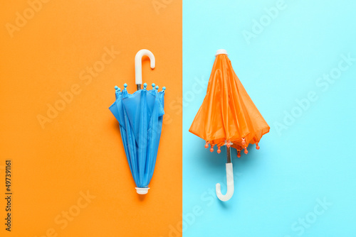 Two small umbrellas on color background photo