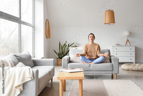 Beautiful young woman medit...