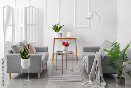 Fototapeta Naklejka Na Ścianę i Meble -  Modern interior of living room with comfortable sofas and stylish tables near white wall