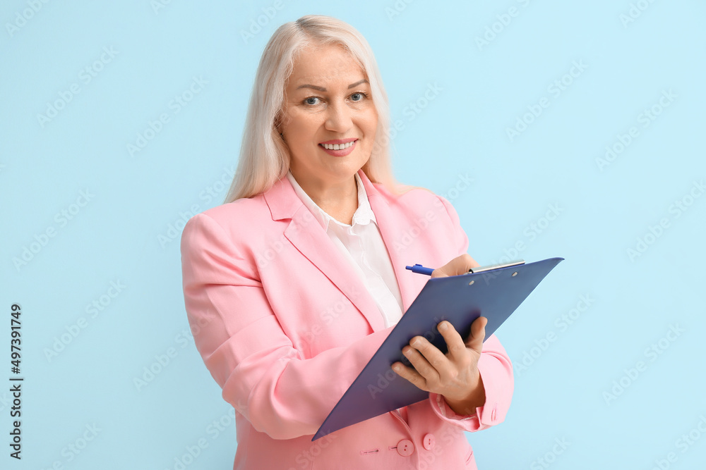 Mature secretary with clipboard on blue background Mature secretary with clipboard on blue background