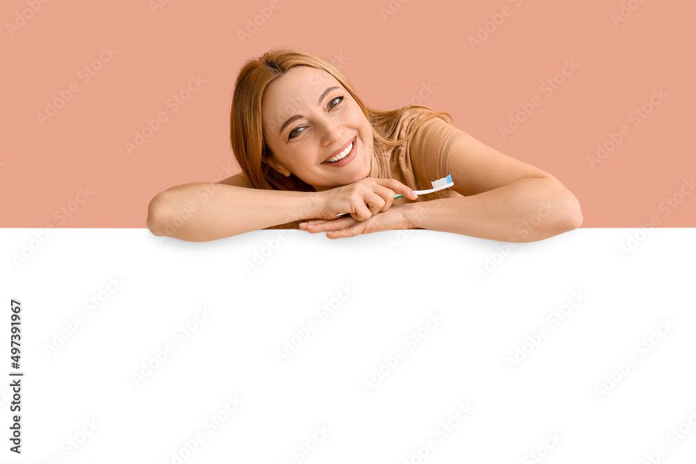 Fototapeta premium Beautiful mature woman with tooth brush and poster on color background