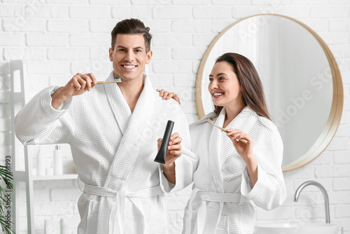 Young couple brushing teeth...