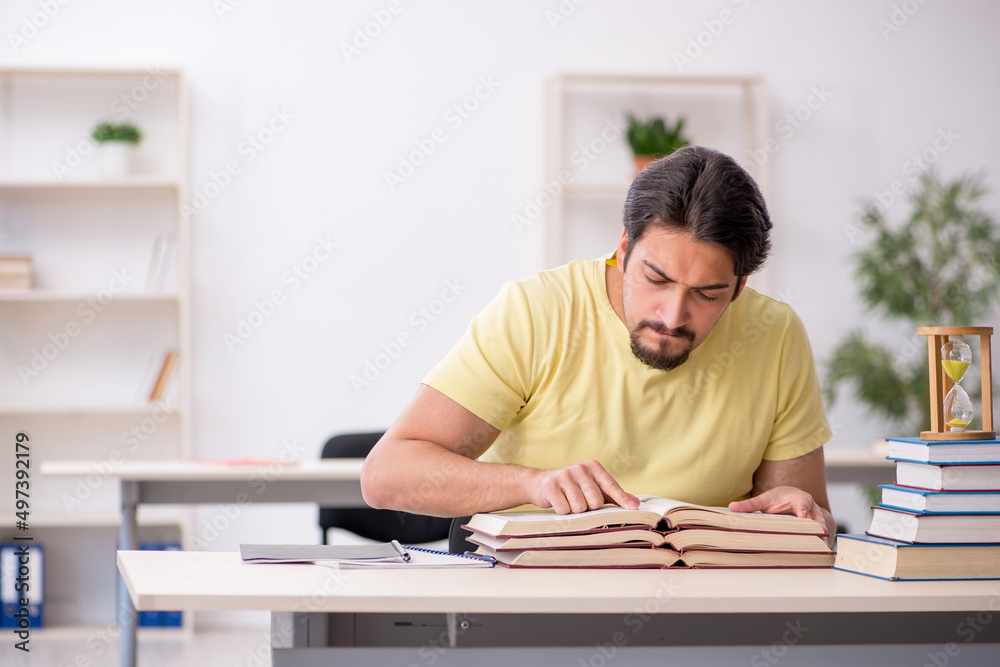 Young male student preparing for exams in time management concep Young male student preparing for exams in time management concep
