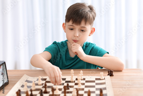 Little boy playing chess du...