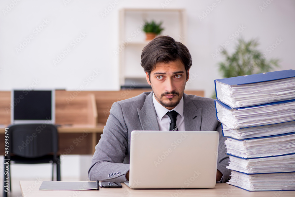 Young male employee unhappy with excessive work in the office
