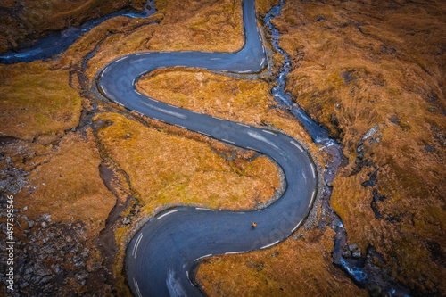 Aerial view on serpentine road on the island Streymoy near the village Nordradalur with view of Koltur island. Faroe Islands, Denmark. November 2021 © Сергій Вовк