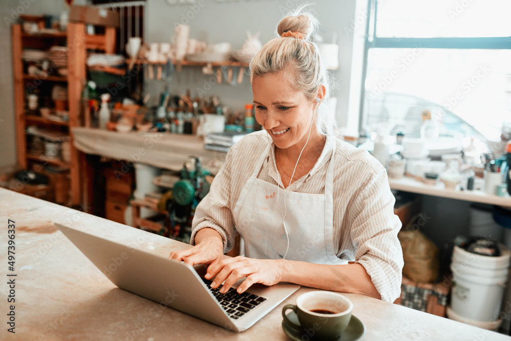 Im trying to keep up with my online sales. Cropped shot of a artisan using a laptop in her workshop. Im trying to keep up with my online sales. Cropped shot of a artisan using a laptop in her workshop.