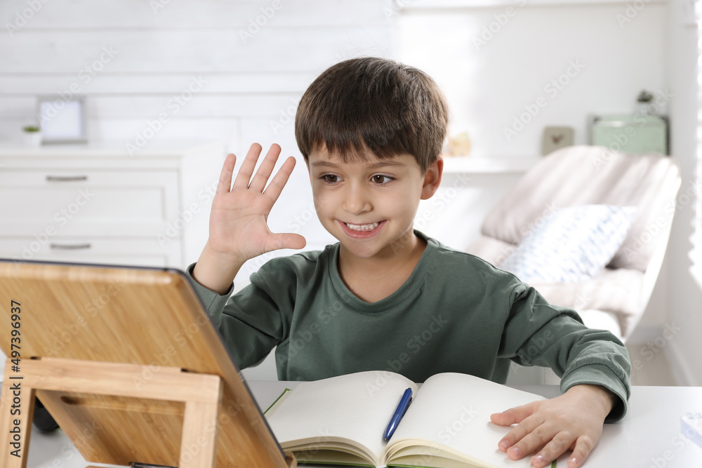 Cute little boy with modern tablet studying online at home. E-learning Cute little boy with modern tablet studying online at home. E-learning