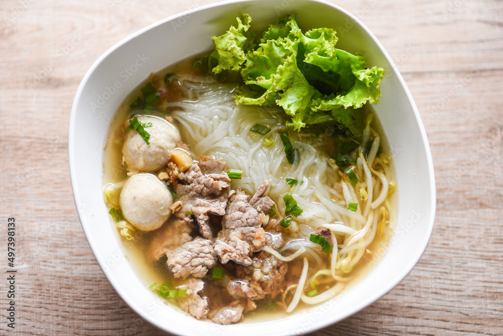 Noodle soup bowl fresh vegetable lettuce pork and Pork balls on wooden background, Thai traditional menu food Noodle soup bowl fresh vegetable lettuce pork and Pork balls on wooden background, Thai traditional menu food