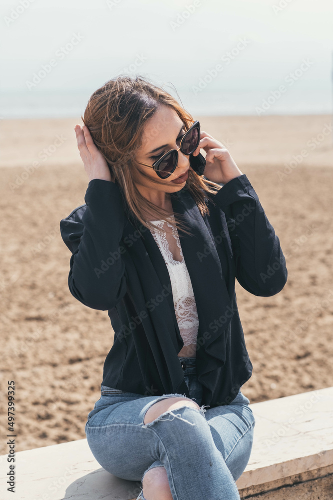 Business woman talking on the phone at beach