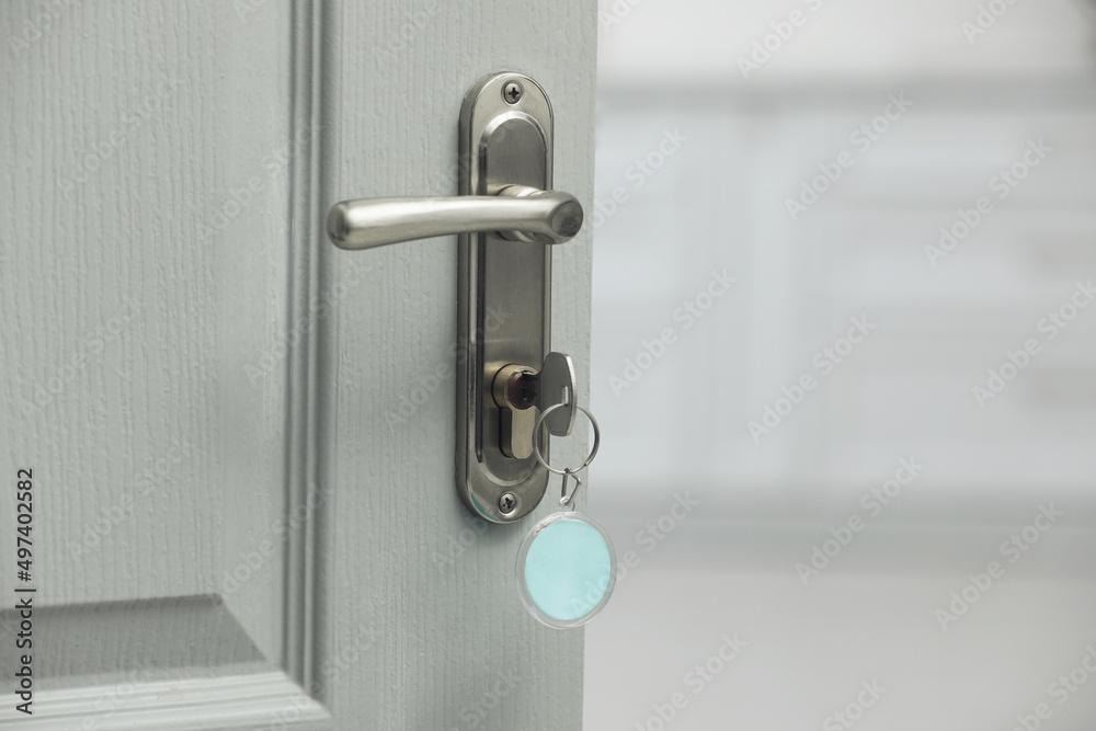 Key with fob in door lock, closeup. Space for text Key with fob in door lock, closeup. Space for text