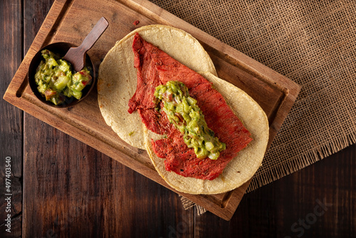 Tacos de Cecina Enchilada con Guacamole. Salted, sun-dried pork or beef meat, seasoned with various spices and chili peppers, usually eaten in tacos photo