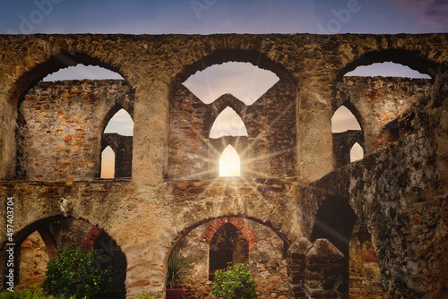 An old Spanish mission in south Texas made of rock and adobe with sunlight.