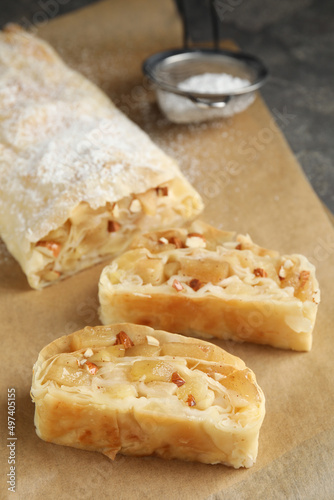 Delicious apple strudel with almonds on parchment, closeup