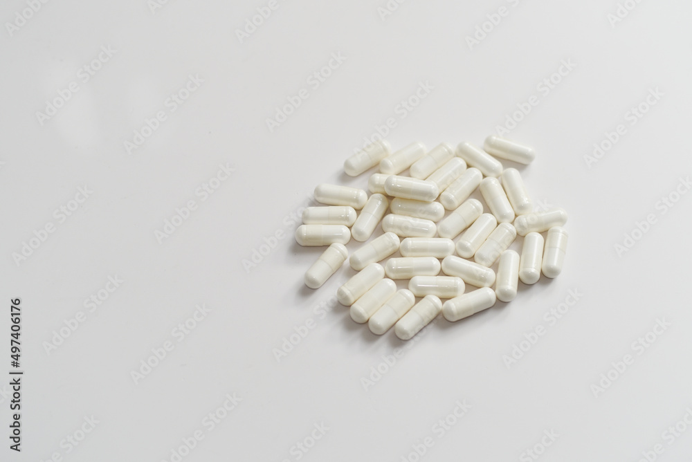 Lot's of white pills on white background for healthcare