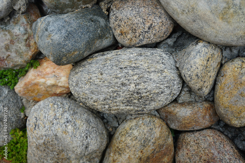 cobble of gneiss metamorphic stones on the rock wall.
